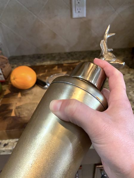 Shaking the apple cider rye cocktail to mix well.