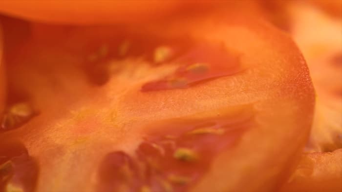 Closeup of orange-colored tomato slices.